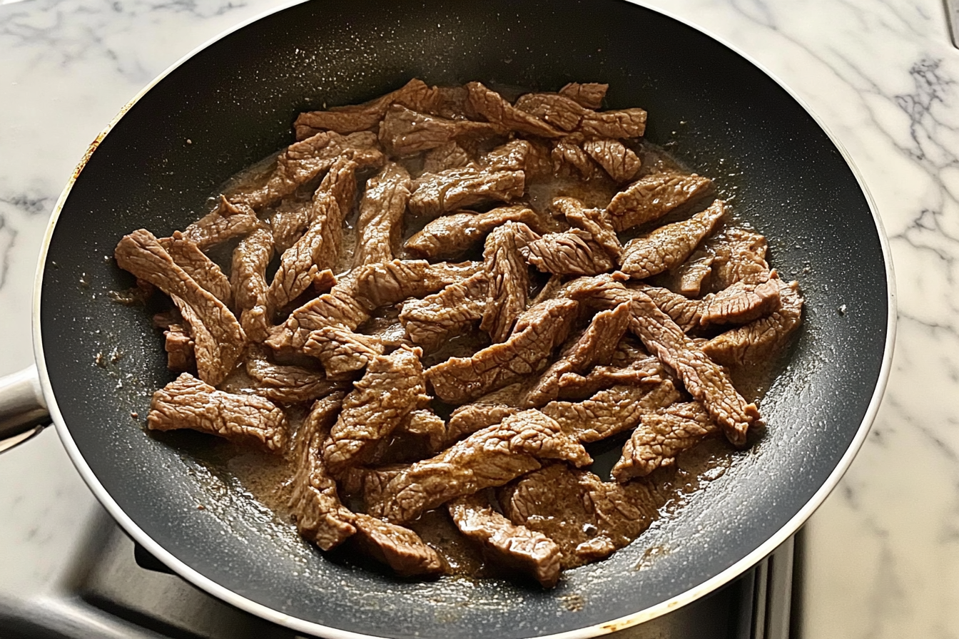 skillet with seared beef strips